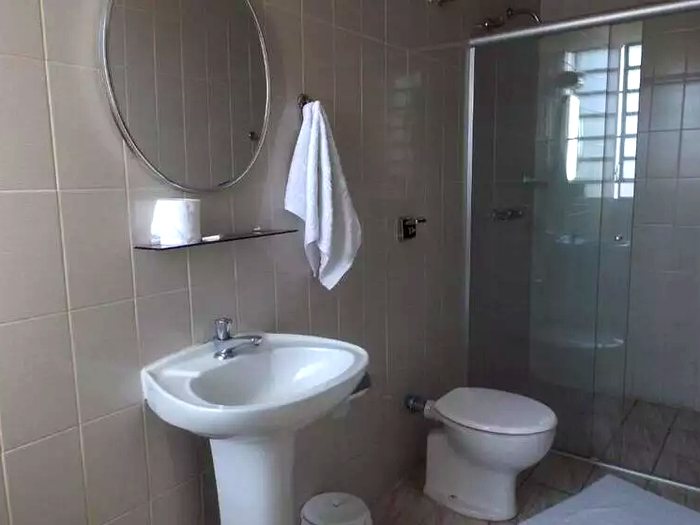 Banheiro do apartamento: box de vidro, água quente e toalhas